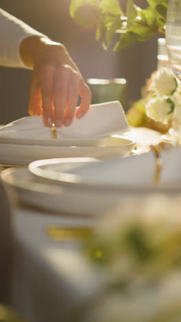 Vertical-Video-Close-Up-Of-Person-Arranging-Vertical-Video-Of-Table-Setting-For-Meal-At-Wedding-Reception